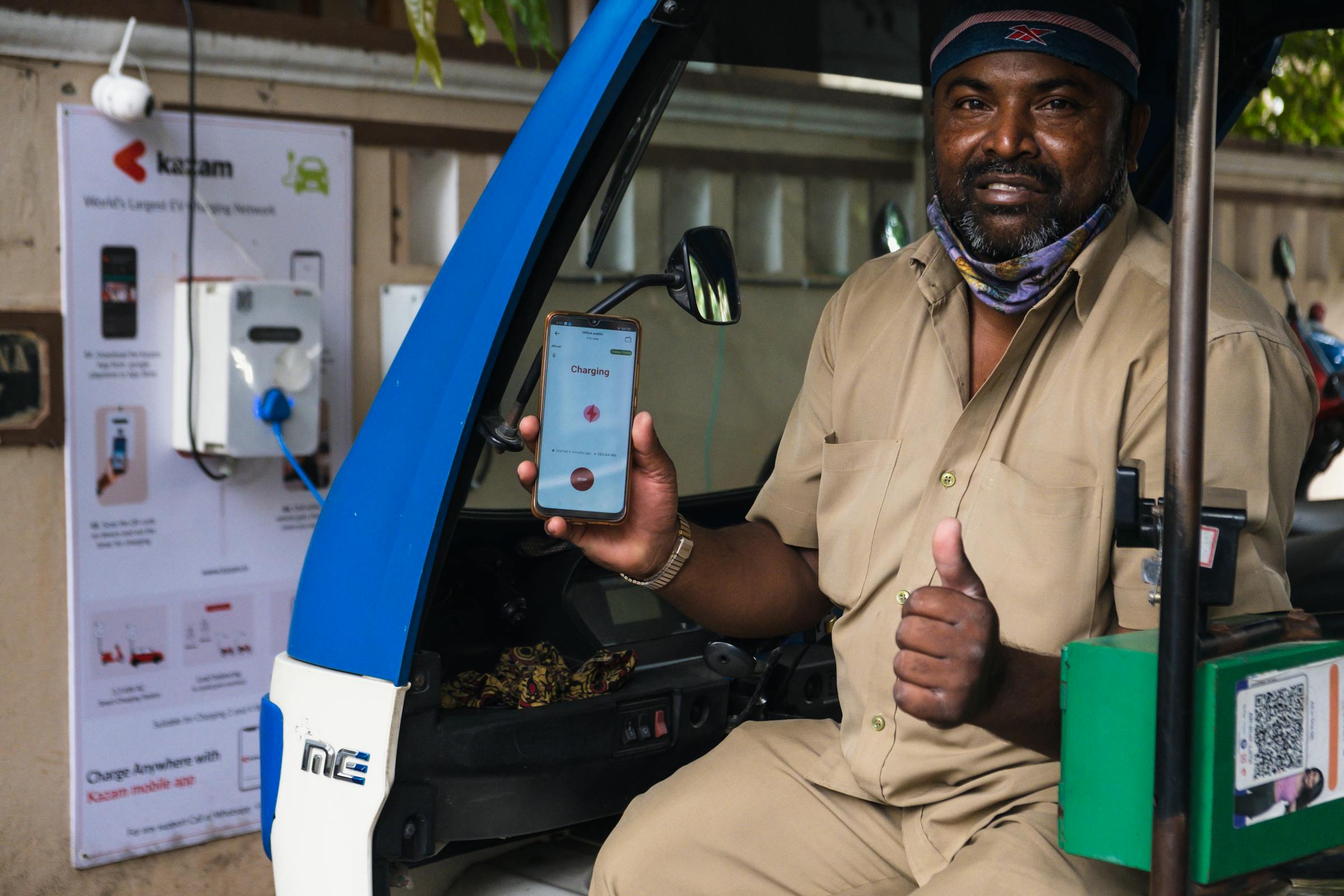 Driver using their smartphone at a charging station