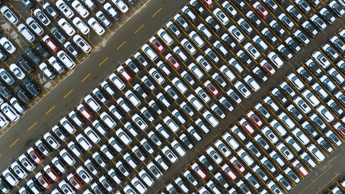 Aerial view of a large car park filled with vehicles lined up in rows
