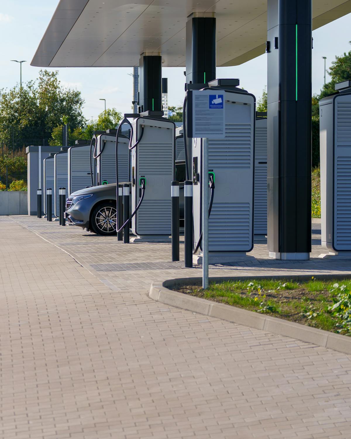 Row of DC fast-charging stations under a canopy
