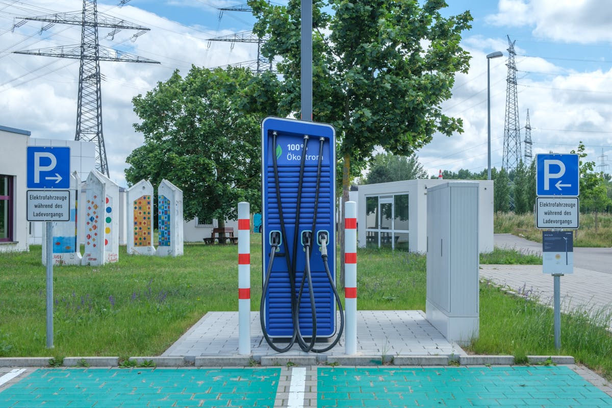 Fast EV charging station in front of high-voltage power pylons
